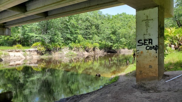 [Wooden piers visible under new bridge]