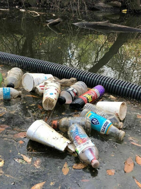 [Closeup trash at boom Sugar Creek 2022-02-11 Photo: Russell McBride]