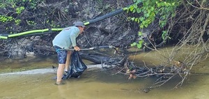 [Scott James picking up trash at the WWALS boom, 09:14:07, 30.8625441, -83.3187415]