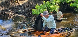 [Scott James picking up trash in his kayak, 09:25:49, 30.8634367, -83.3190541]