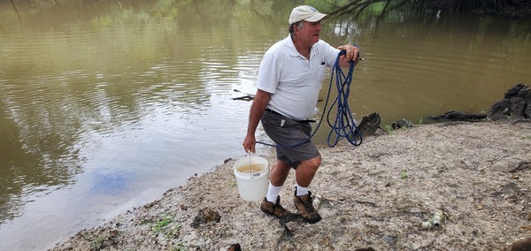 Michael Bachrach taking sample bucket to car, 10:52:38, 30.7123453, -83.4555396