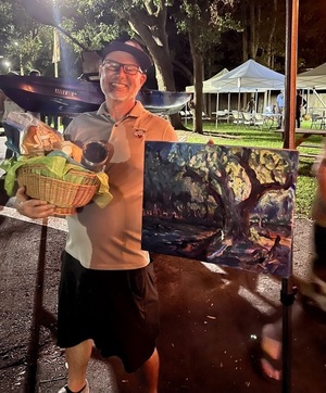 [Raffle Kayak won by Mala Vallotton; Steve Miller with Okra Paradise Farms food and Julie Bowland painting]