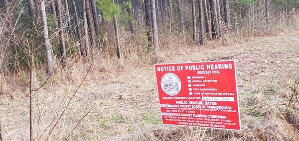 Rezoning notice sign with planted pines to be cleared, Peach Road east side, 17:43:34, 30.9510626, -83.4834273