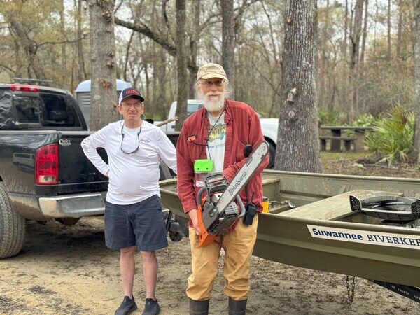 [Phil Royce, Suwannee Riverkeeper John S. Quarterman with Wild Green Future Chainsaw and Suwannee Riverkeeper jon boat --Valdosta, A City Without Limits]