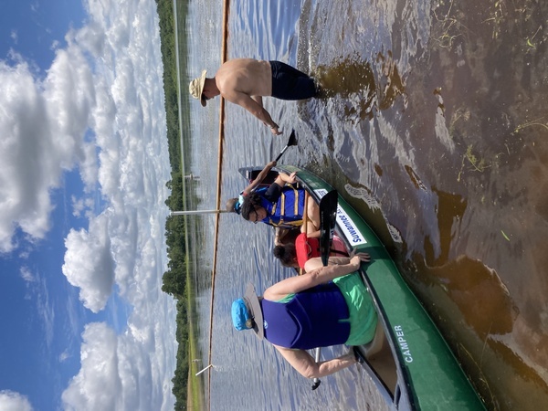 [Jo getting in with children in the Camper canoe, Dan Phillips helping, 12:27:39 --Gretchen Quarterman]