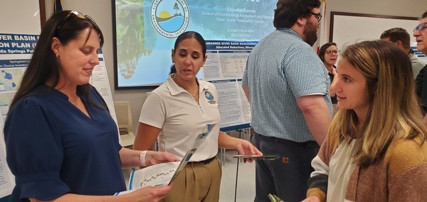 [FDEP examining a WWALS WLRWT z-fold brochure, r: Kathryn (Katie) Craver, Government Operations Consultant III, Northeast District]