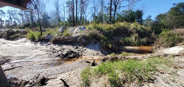 Two manholes, sewer line exposed, Sherwood Drive, RR trestle, 2025:01:02 12:52:49, 30.8527033, -83.3150779