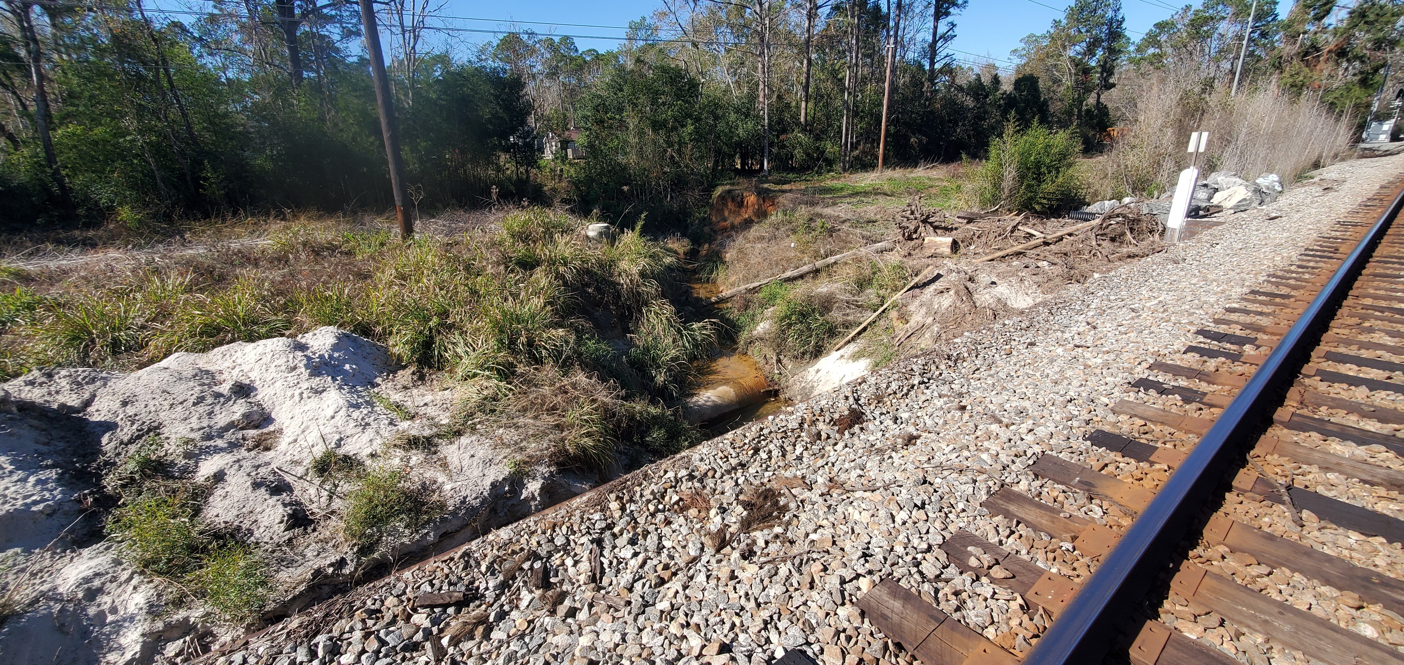 Sewer line exposed below Sherwood Drive by RR trestle, Sugar Creek, 2025:01:02 12:41:57, 30.8526588, -83.3148423