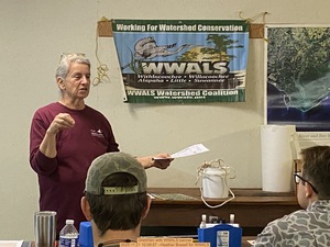 [Gretchen with WWALS banner, 2025:11:21 10:09:57 --Heather Brasell for WWALS]