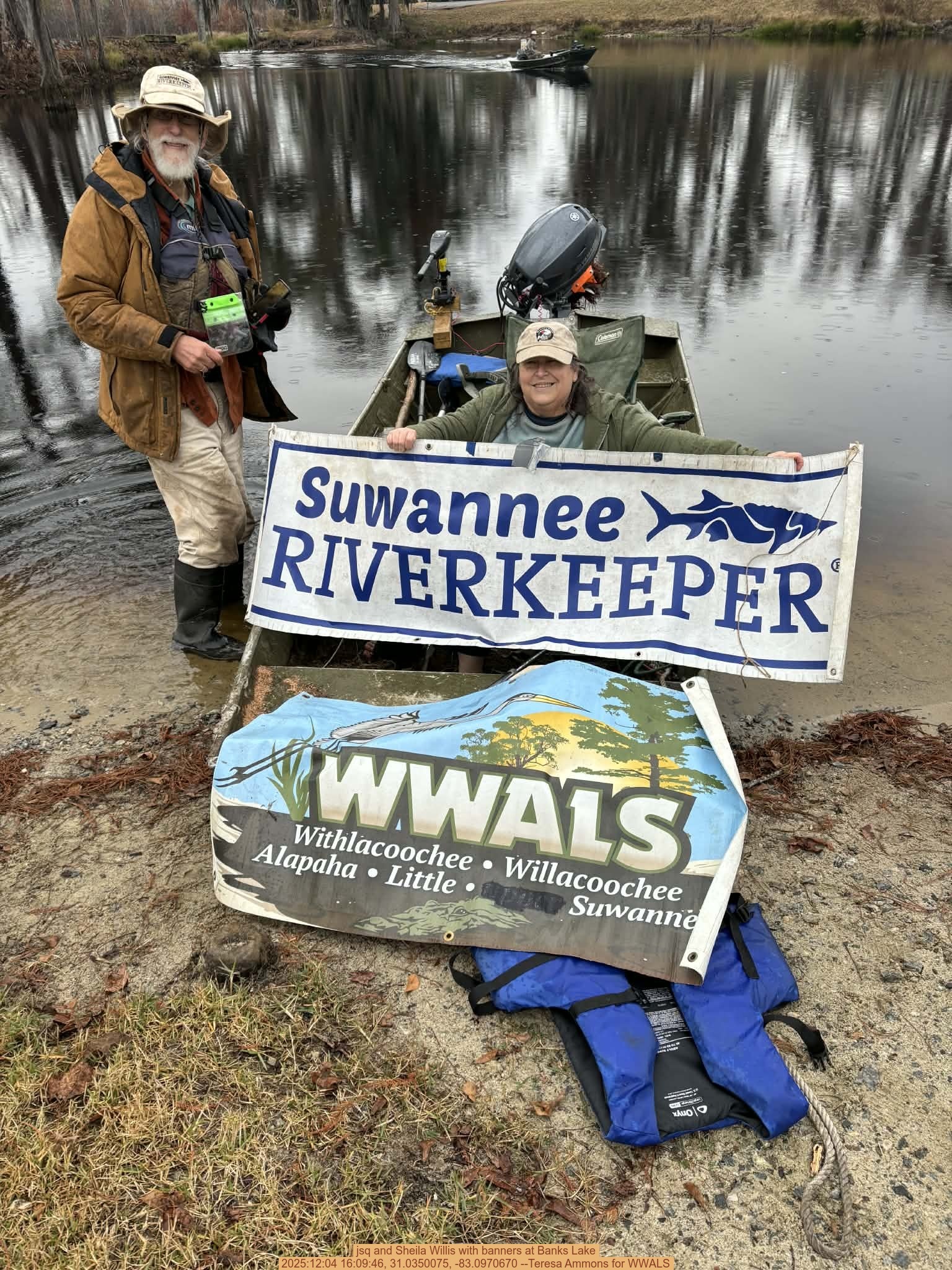 jsq and Sheila Willis with banners at Banks Lake, 2025:12:04 16:09:46, 31.0350075, -83.0970670 --Teresa Ammons for WWALS