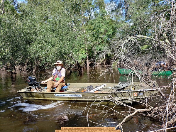 [Suwannee Riverkeeper jon boat attempting to pull debris, 2024-08-25, 10:40:53, 30.89038, -83.32129 --Phil Royce for WWALS]
