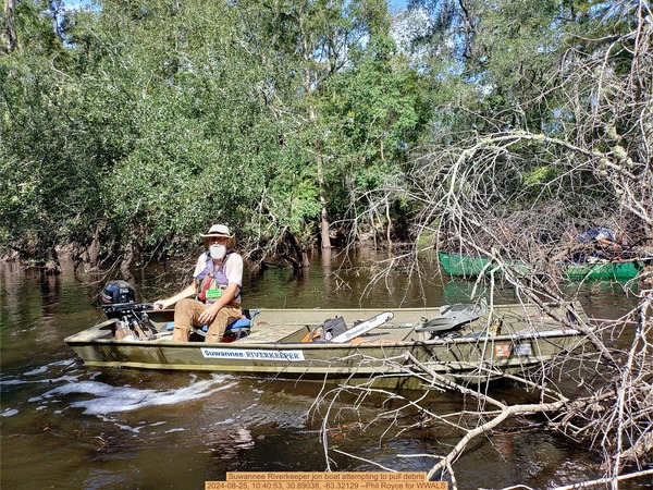 [Suwannee Riverkeeper jon boat attempting to pull debris, 2024-08-25, 10:40:53, 30.89038, -83.32129 --Phil Royce for WWALS]