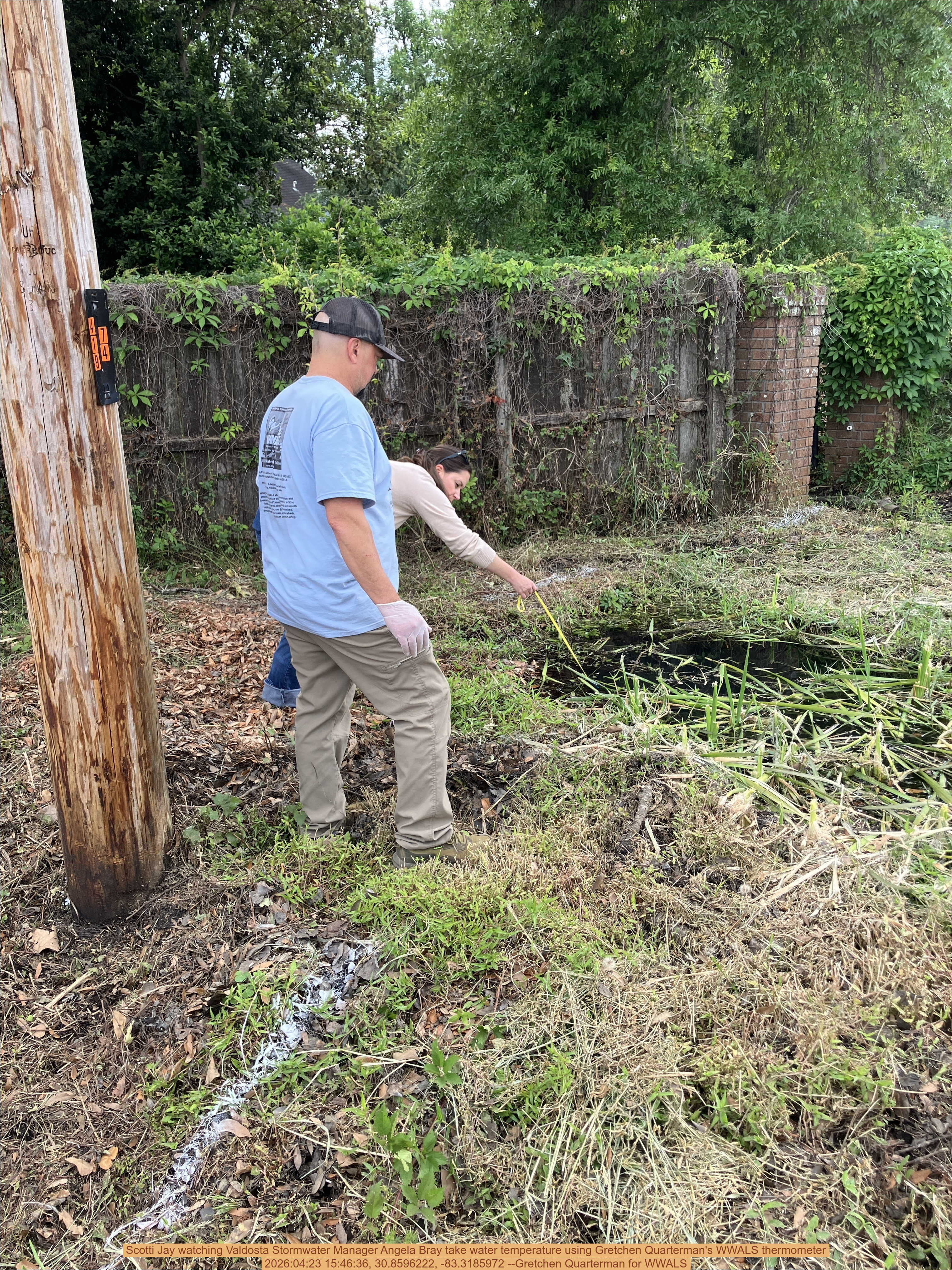 Scotti Jay watching Valdosta Stormwater Manager Angela Bray take water temperature using Gretchen Quarterman's WWALS thermometer, 2026:04:23 15:46:36, 30.8596222, -83.3185972 --Gretchen Quarterman for WWALS
