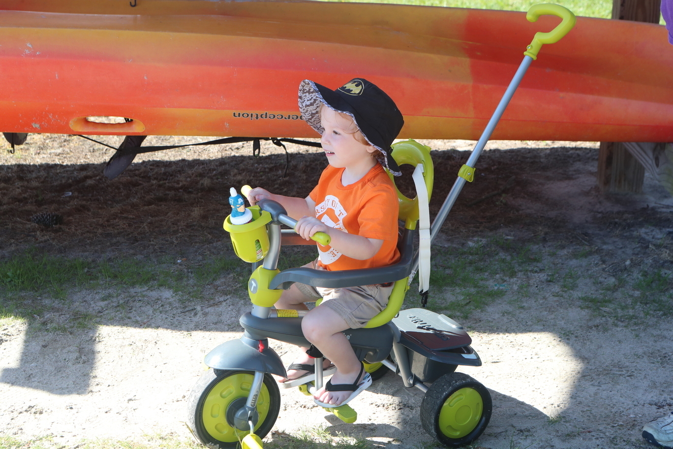 Child, tricycle, and kayak