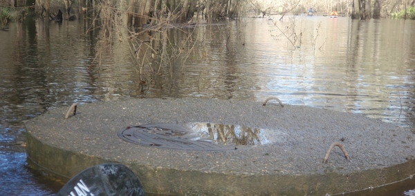 Manhole cover and paddlers, 09:43:13, 30.8355220, -83.3586490