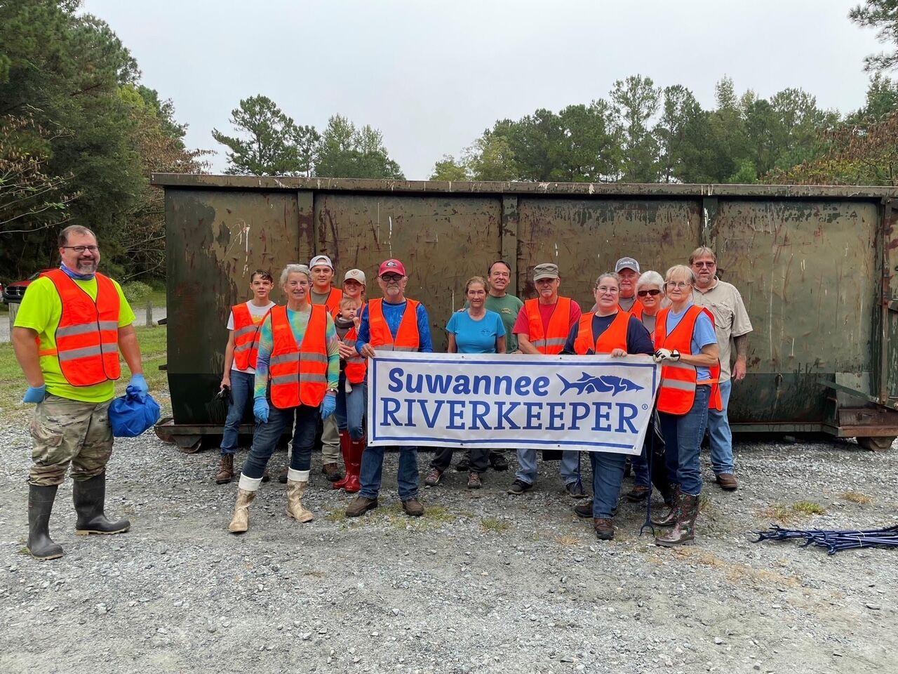 Suwannee Riverkeeper banner at a Troupville cleanup. Lowndes County Chairman Bill Slaughter is second from right, back row. WWALS E.D. Gretchen Quarterman is by the left end of the banner.