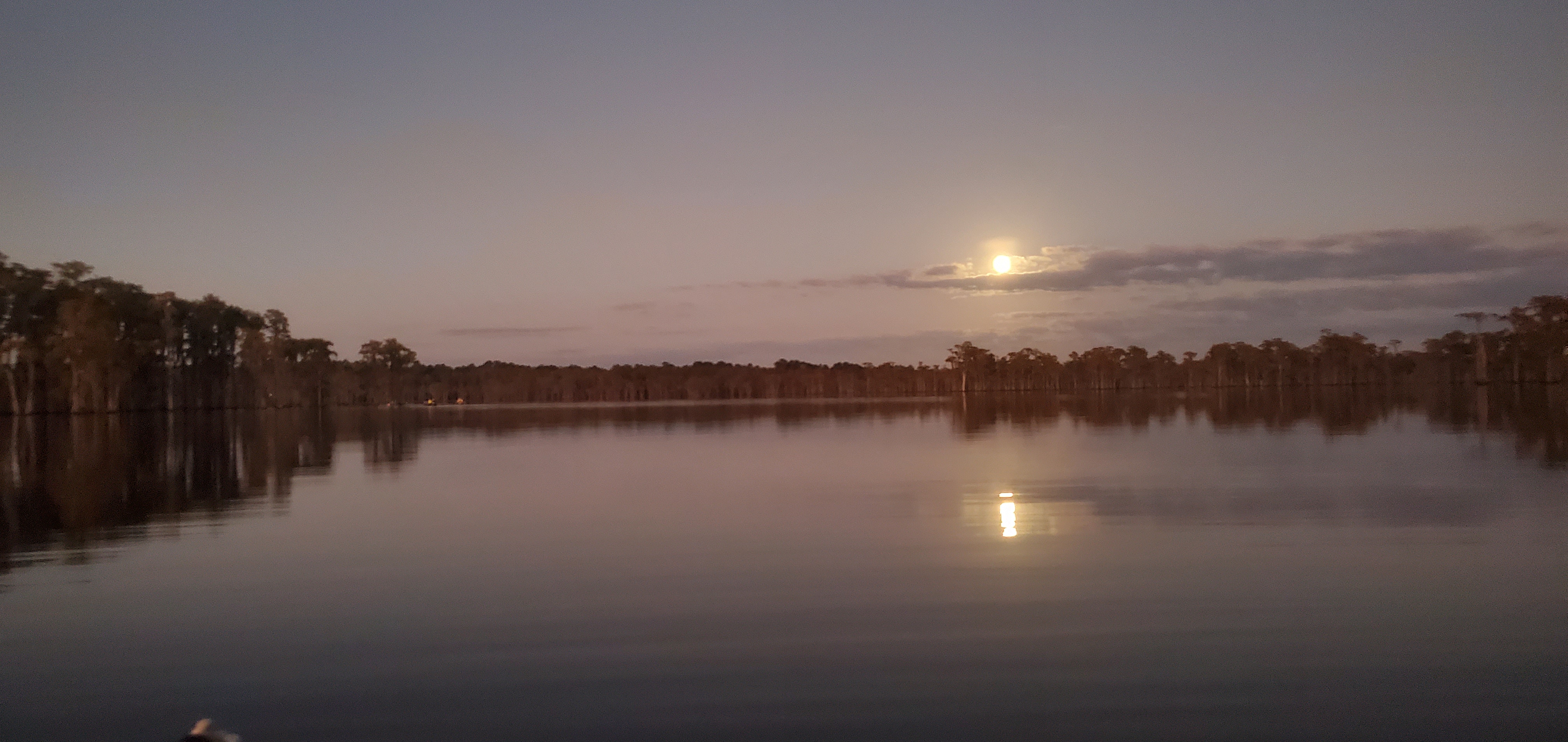 Boats, moon above dark cloud