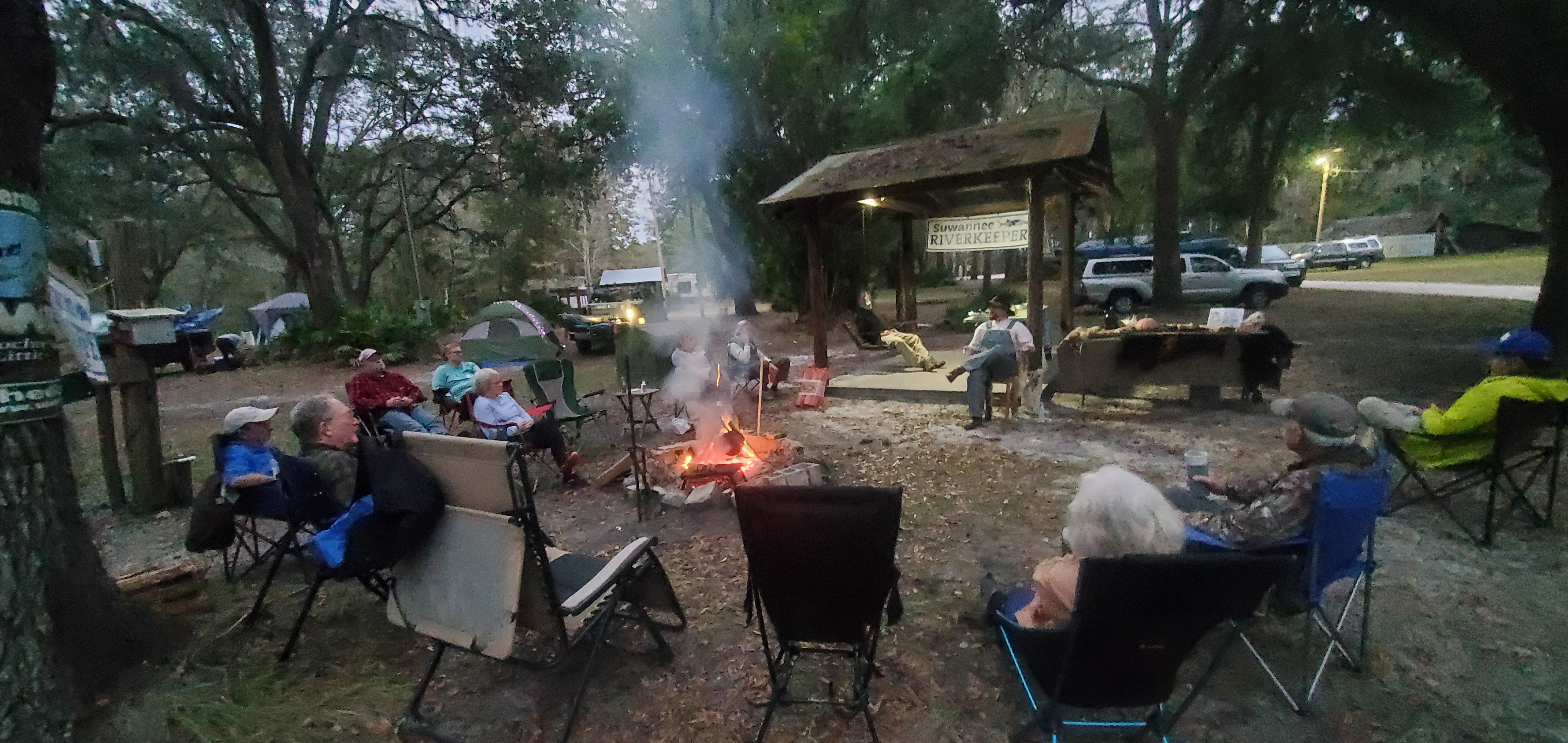 Campfire circle listening to C.B. Adams