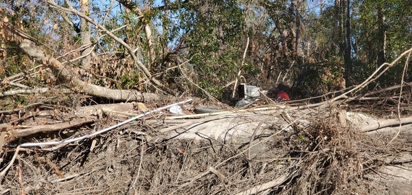 Trash on right (east) bank, Sugar Creek in front of Berta's Kitchen, 2024-12-12, 13:48:29, 30.8612116, -83.3178400