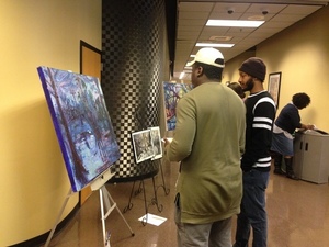 Students look at a painting by Julie Bowland